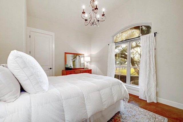 bedroom featuring wood finished floors, baseboards, and a chandelier