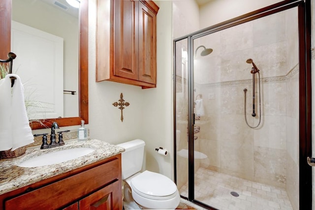 bathroom featuring visible vents, a stall shower, toilet, and vanity