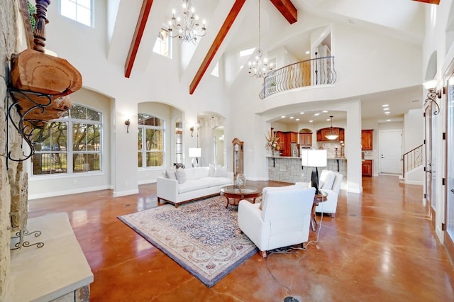 living room featuring baseboards, a healthy amount of sunlight, finished concrete flooring, and an inviting chandelier