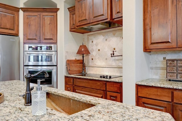 23923 Tres Coronas, Spicewood, TX 78669 - kitchen with stainless steel appliances, backsplash, a sink, and light stone counters