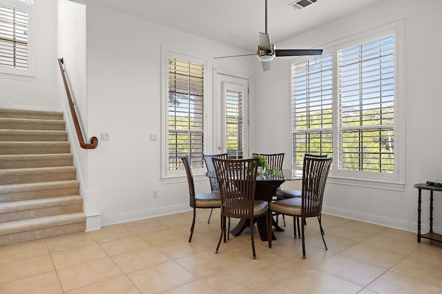 dining area featuring light tile patterned floors, stairway, baseboards, and ceiling fan