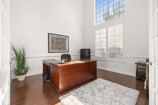 home office with plenty of natural light, baseboards, and dark wood-style flooring