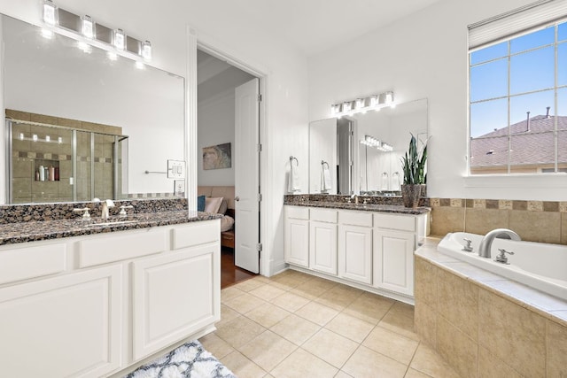 full bathroom with a garden tub, two vanities, a stall shower, a sink, and tile patterned flooring