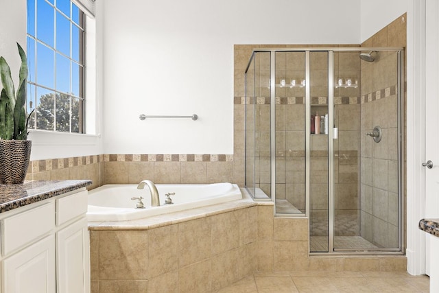 bathroom featuring tile patterned floors, a stall shower, and a bath