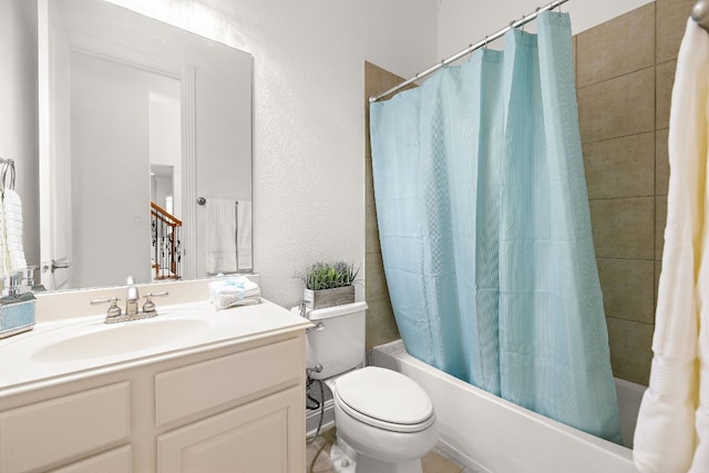 bathroom with vanity, toilet, shower / tub combo, and a textured wall