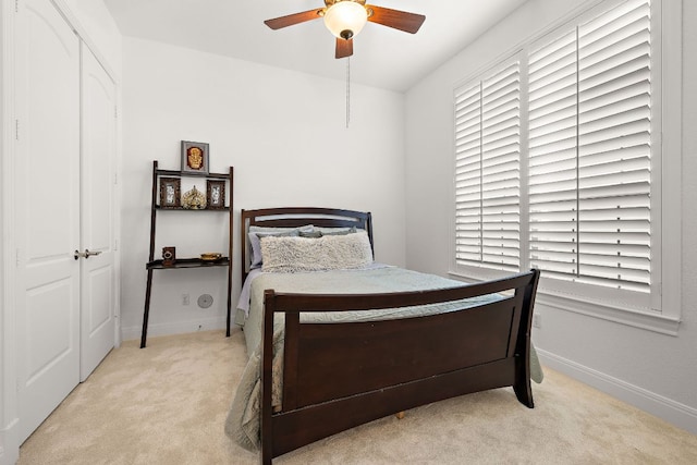 carpeted bedroom featuring baseboards and a ceiling fan