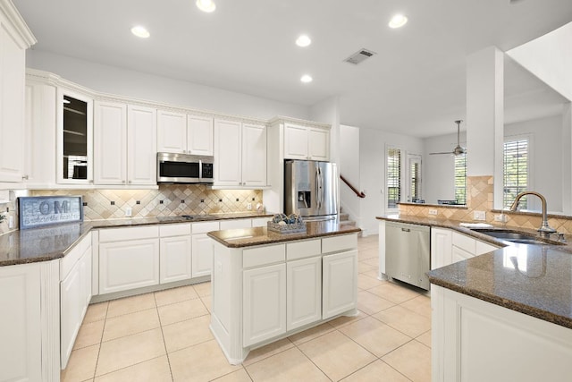 kitchen featuring visible vents, a sink, appliances with stainless steel finishes, white cabinetry, and tasteful backsplash