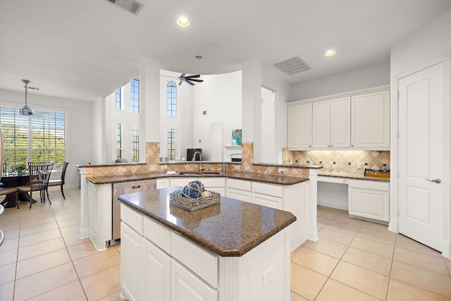 kitchen featuring visible vents, dishwasher, a kitchen island, and a sink