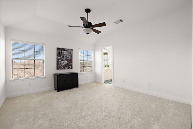 carpeted empty room with baseboards, visible vents, a ceiling fan, and lofted ceiling