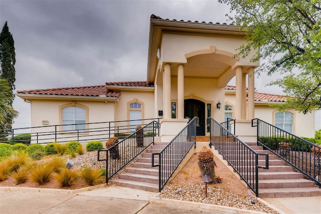 mediterranean / spanish home with stucco siding and a tile roof