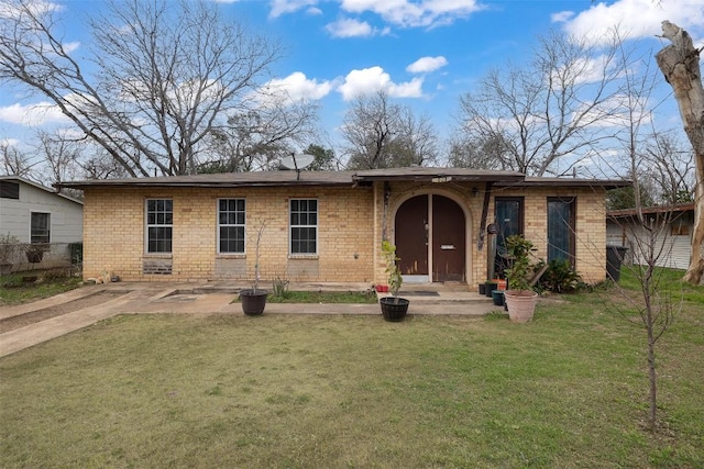 view of front of house featuring a front yard, fence, and brick siding