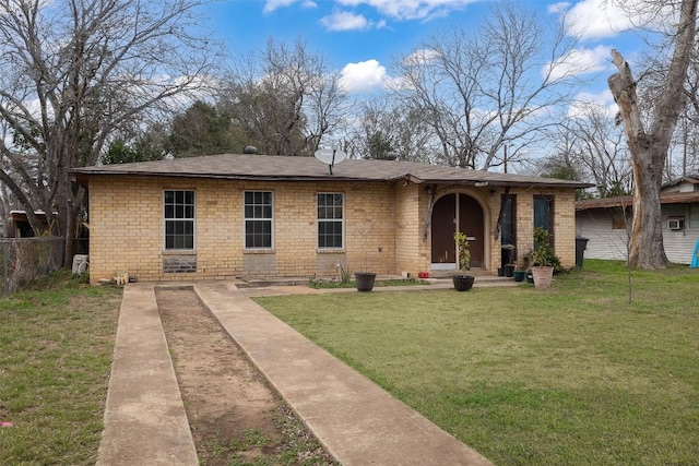 view of front of house with brick siding, a front lawn, and fence