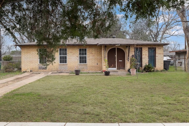 ranch-style home with brick siding, a front yard, and fence