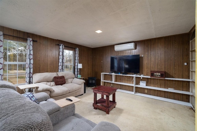 living area with a wall unit AC, carpet, and wood walls