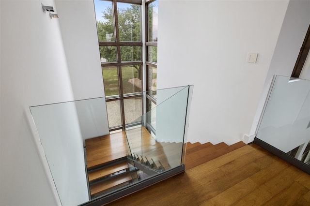 stairs with baseboards, plenty of natural light, and wood finished floors