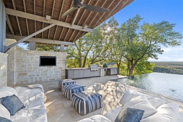 view of patio / terrace featuring ceiling fan, area for grilling, and an outdoor kitchen