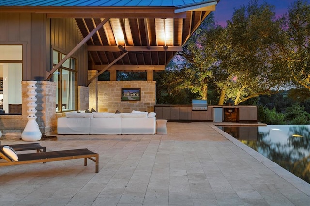 view of patio / terrace with area for grilling, an outdoor kitchen, and an outdoor living space with a fireplace