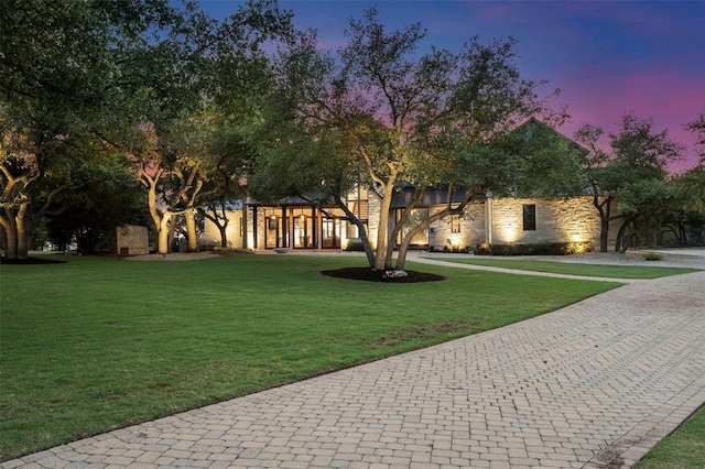 view of front of home featuring a front lawn and stone siding