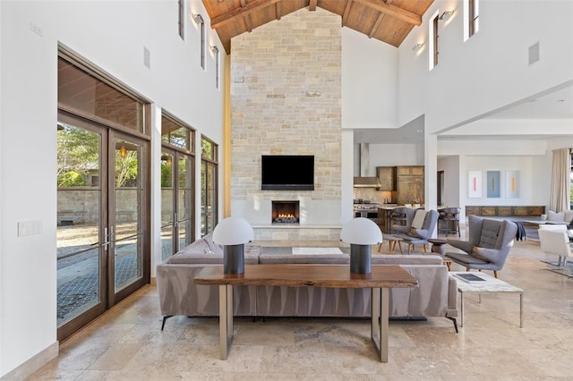 living room featuring a fireplace, wooden ceiling, french doors, and beam ceiling