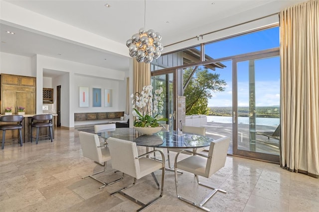 dining area with an inviting chandelier and a water view