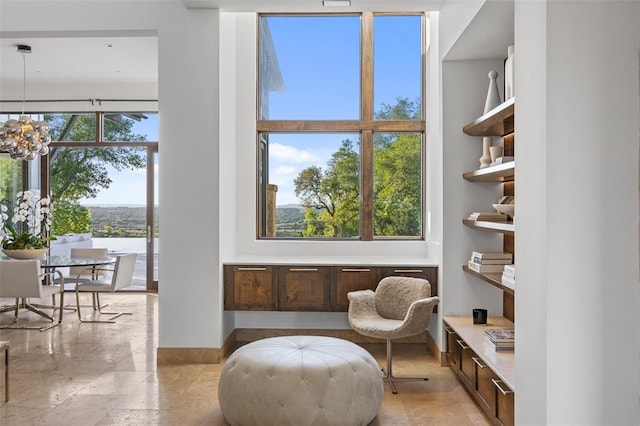 living area with a notable chandelier and baseboards