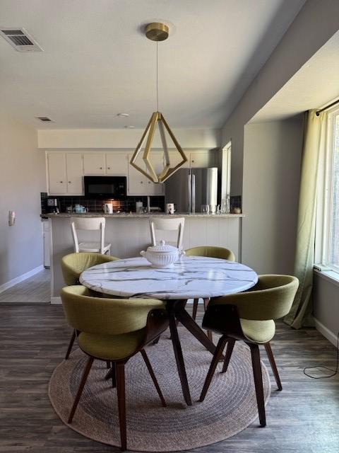 dining space featuring visible vents, baseboards, and dark wood-style flooring