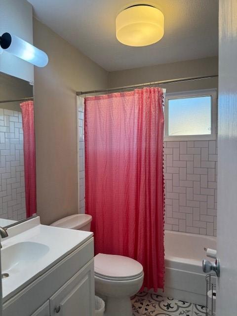 bathroom featuring tile patterned flooring, shower / bath combo with shower curtain, toilet, and vanity