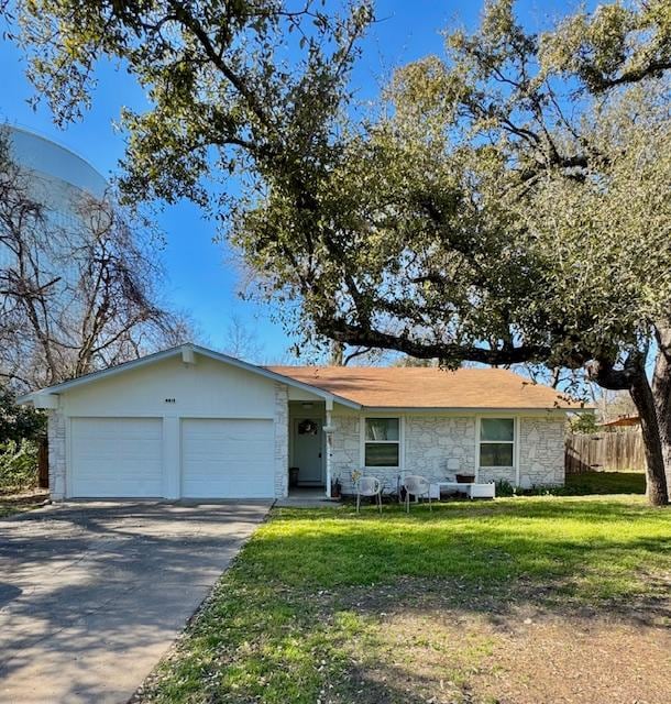 ranch-style house featuring driveway, stone siding, fence, a front yard, and a garage