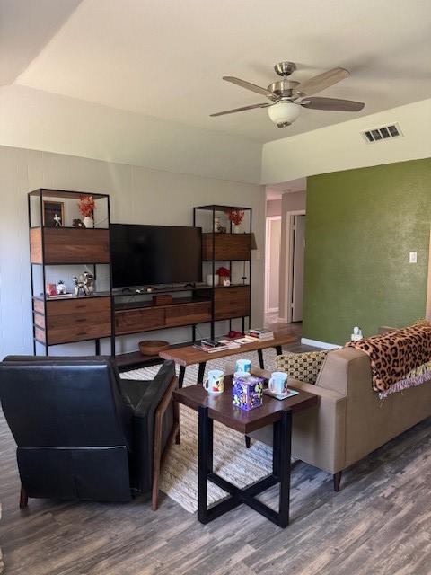 living area featuring wood finished floors, visible vents, and ceiling fan