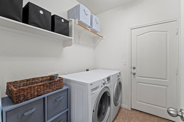 clothes washing area featuring laundry area, light tile patterned floors, washing machine and dryer, and baseboards