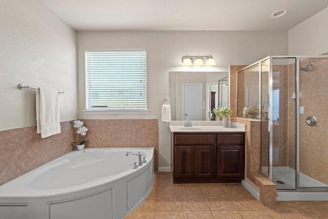 bathroom featuring vanity, a garden tub, a shower stall, and tile patterned flooring