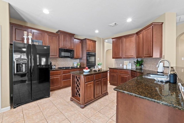 kitchen with arched walkways, visible vents, black appliances, and a sink