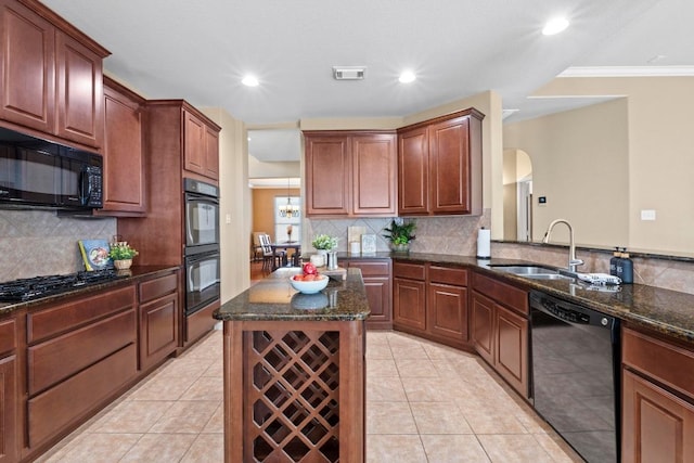 kitchen with black appliances, dark stone counters, light tile patterned floors, and a sink