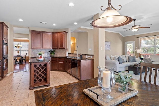 kitchen with tasteful backsplash, open floor plan, black dishwasher, arched walkways, and a sink