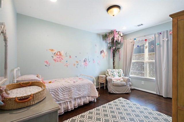 bedroom featuring wood finished floors, visible vents, and baseboards