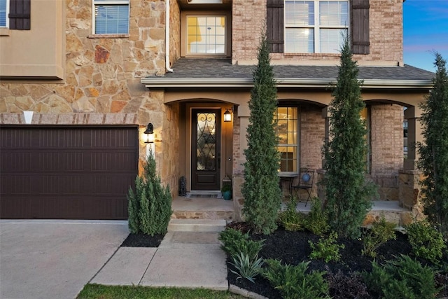 doorway to property featuring a porch, brick siding, and a garage