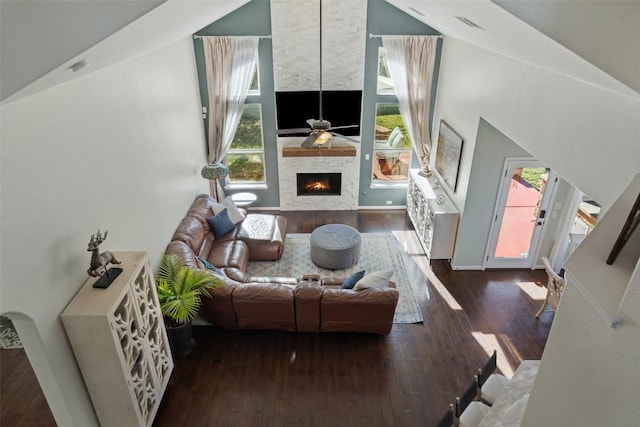 living room featuring plenty of natural light, a fireplace, ceiling fan, and wood finished floors