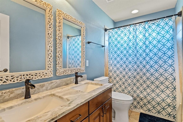 full bathroom featuring tile patterned flooring, double vanity, toilet, and a sink