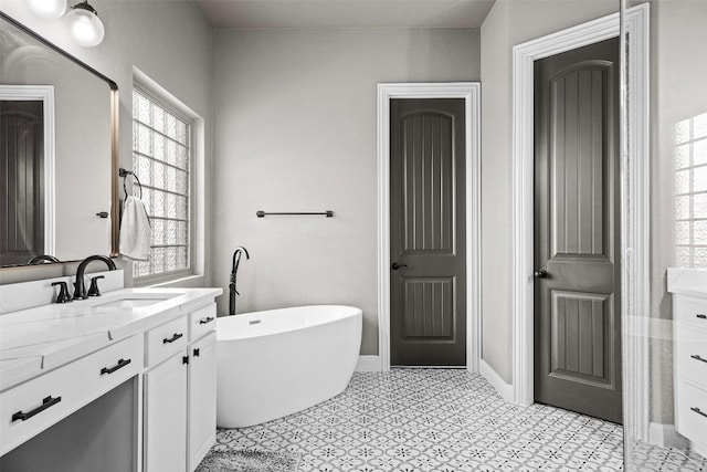 full bathroom featuring baseboards, a freestanding bath, and vanity