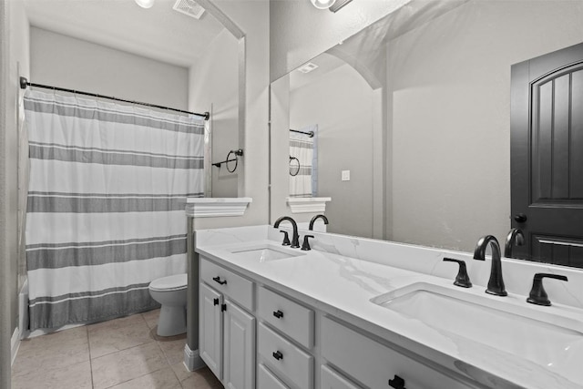 full bath featuring a sink, toilet, double vanity, and tile patterned floors