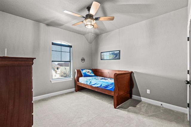 carpeted bedroom with vaulted ceiling, baseboards, and ceiling fan