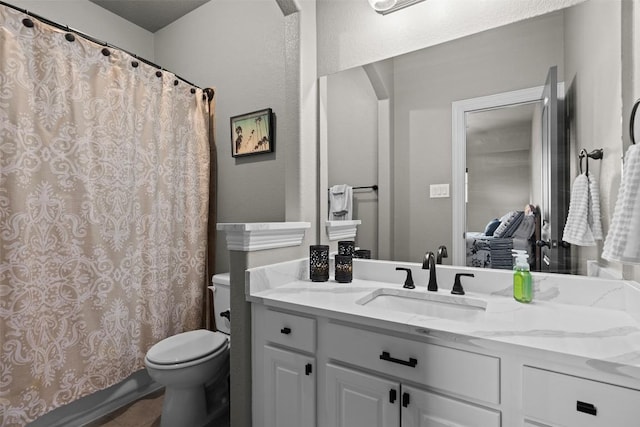 bathroom with curtained shower, toilet, and vanity