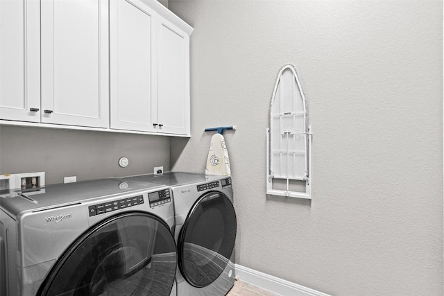 laundry area with washer and dryer, wood finished floors, cabinet space, and baseboards