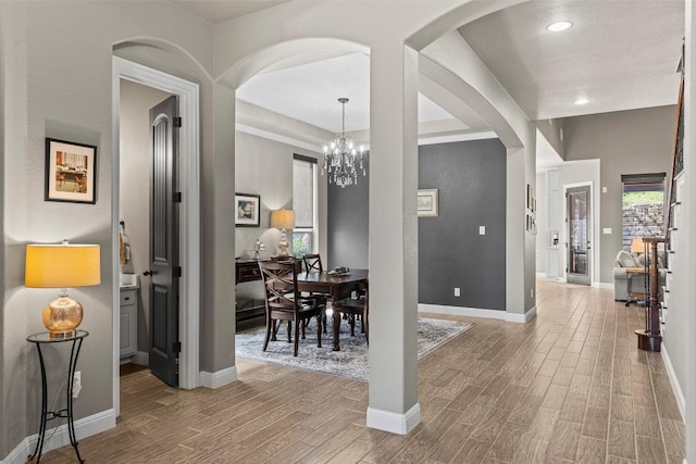 foyer entrance featuring an inviting chandelier, wood finished floors, baseboards, and a wealth of natural light