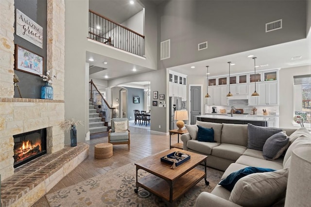 living room with visible vents, a fireplace, and stairway