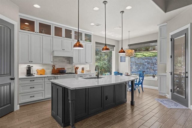 205 Varco Dr, Austin, TX 78738 - kitchen featuring stainless steel gas cooktop, wood finished floors, decorative backsplash, white cabinets, and recessed lighting
