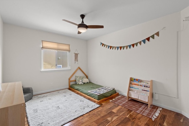 bedroom featuring a ceiling fan, wood finished floors, and baseboards