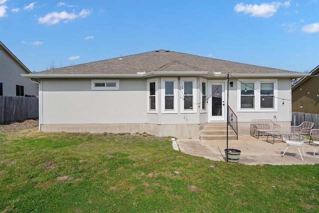 back of property featuring entry steps, a yard, and fence