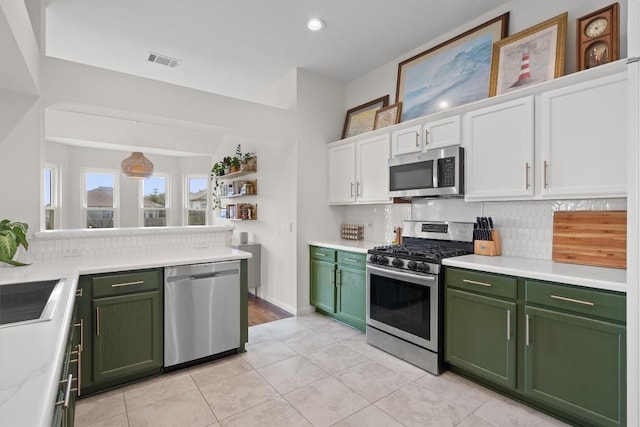 kitchen with white cabinets, stainless steel appliances, visible vents, and green cabinetry