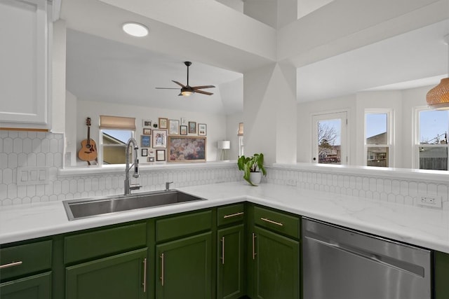 kitchen featuring a sink, backsplash, light countertops, green cabinetry, and dishwasher